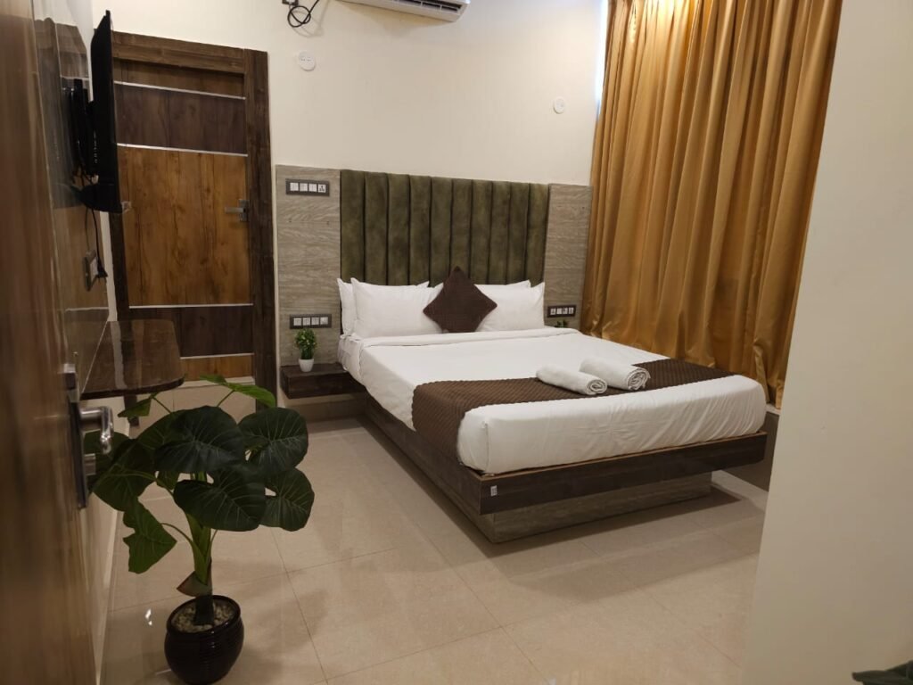 Air conditioned room with double bed and wall-mounted TV at Hotel Sky International, Shamshabad